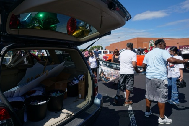 Balloons and supplies being loaded into the back of the Kumbha-Yah vehicle before the parade