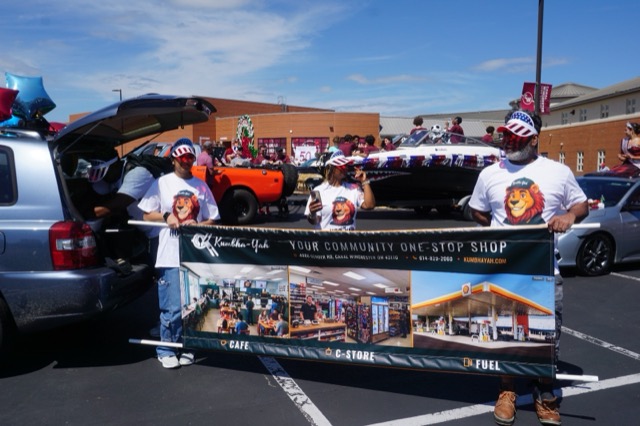 The team holding up the Kumbha-Yah banner, which shows the cafe, the c-store and the fuel forecourt