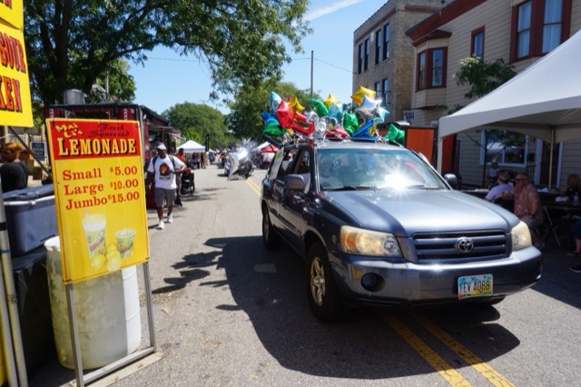 The balloon-covered Kumbha-Yah vehicle passing a lemonade stand in downtown Canal Winchester